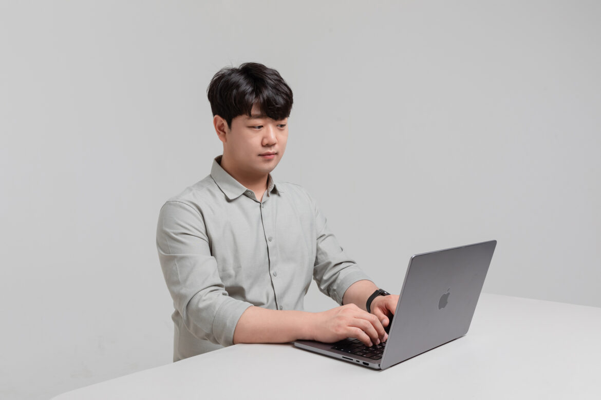 협업툴 컨설턴트 전시진이 책상에 앉아 맥북을 두드리고 있는 모습